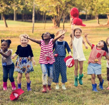 Öğrenciler parkta kırmızı kapaklar