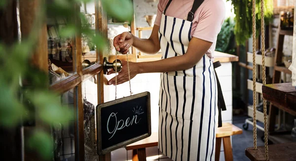 African woman in apron working in shop — Stock Photo, Image