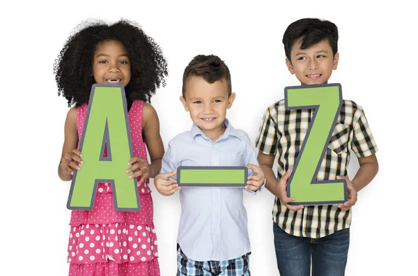 Niños sosteniendo cartas de papel A-Z —  Fotos de Stock