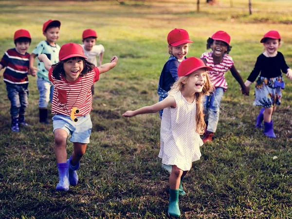 Kinderen in Red Caps plezier — Stockfoto