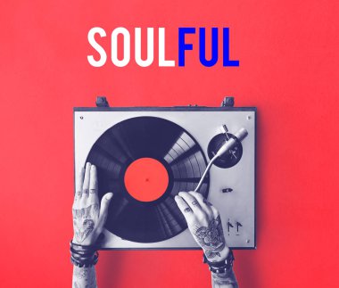 Vinil player ile dövmeli kişi.