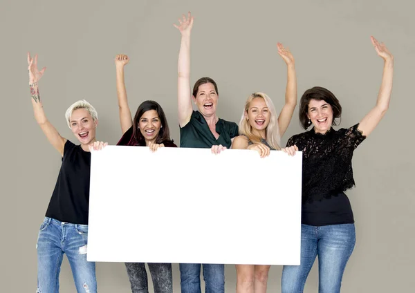 Mujeres sonrientes sosteniendo banner vacío — Foto de Stock