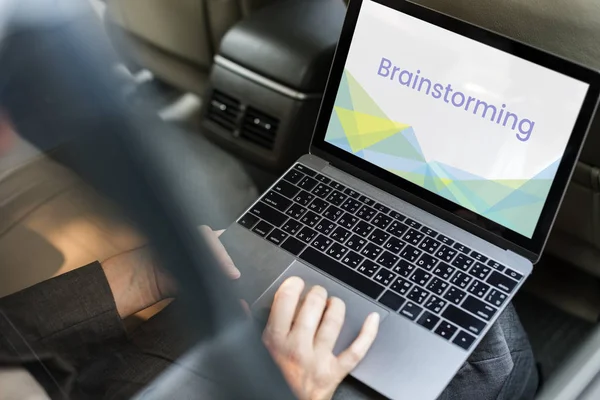Empresario que utiliza el ordenador portátil en coche — Foto de Stock