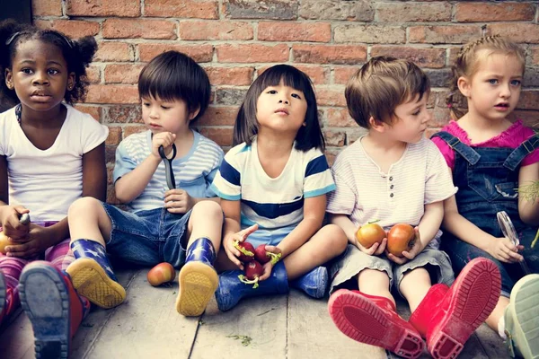 Kinderen zitten met verse groenten — Stockfoto