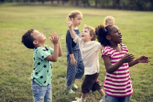 Діти грають з мильними бульбашками — стокове фото