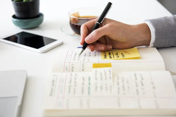 Businessperson writing notes in diary — Stock Photo, Image