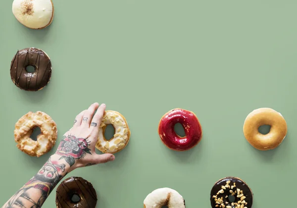 Tatuado mano selección donuts — Foto de Stock