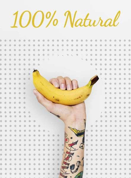 Tattooed person holding banana. — Stock Photo, Image