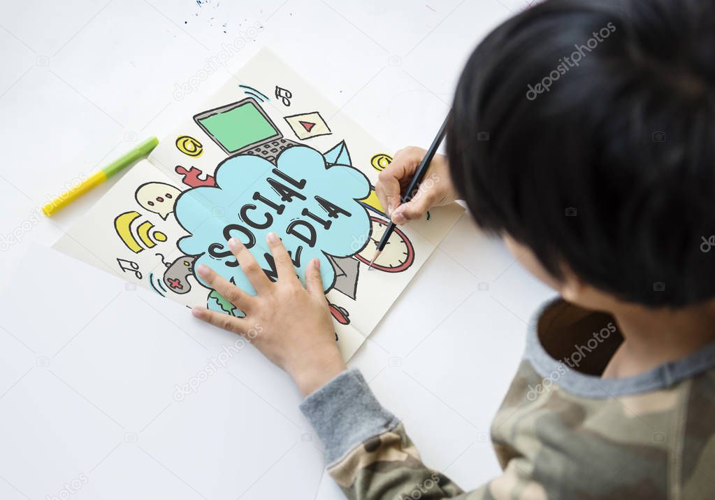 Boy lying on floor and writing with pencil on paper, title: Social Media