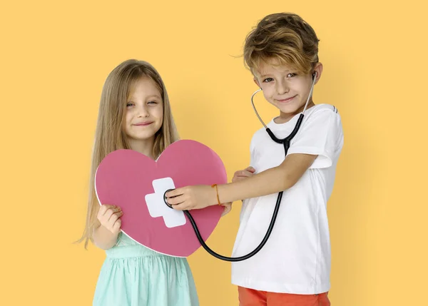Barn lyssnar hjärtat med stetoskop — Stockfoto