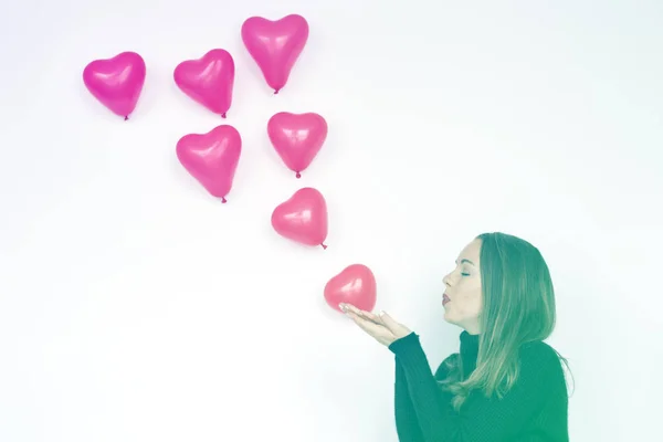 Kobieta dmuchanie balonów serca — Zdjęcie stockowe