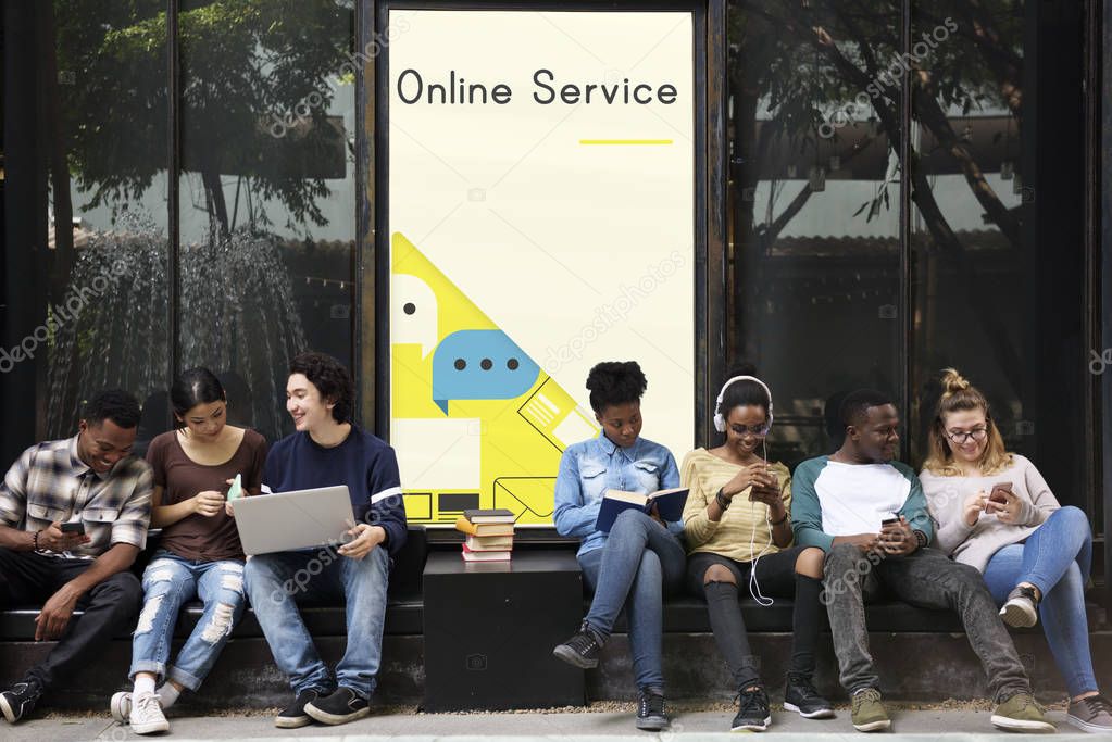 Group of young students studying together, siting near placard with title: Online Service