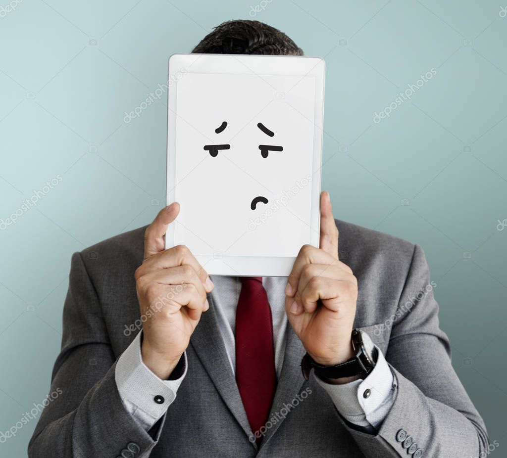 Businessman covering face with digital tablet