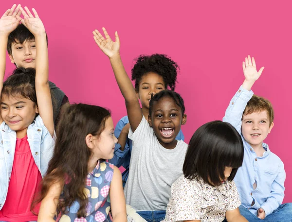 Crianças em idade escolar levantando as mãos — Fotografia de Stock