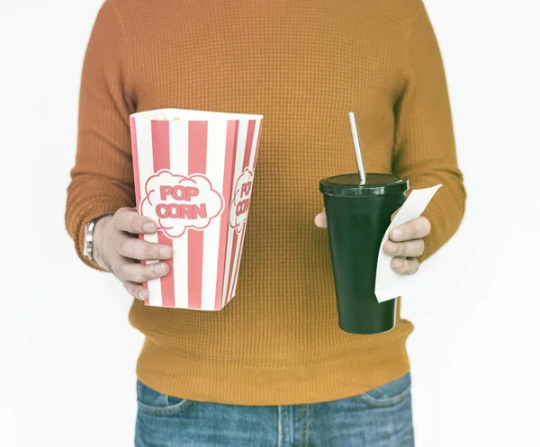 Чоловік тримає попкорн і напій з квитком — стокове фото