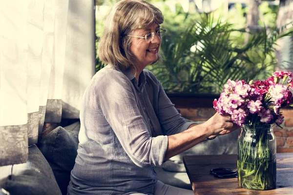 Zralá dáma aranžování květin — Stock fotografie