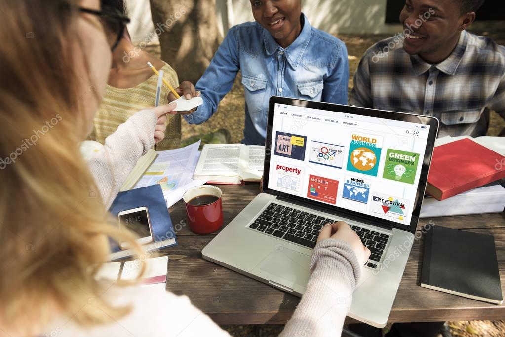 Students sitting at table with books and laptop 