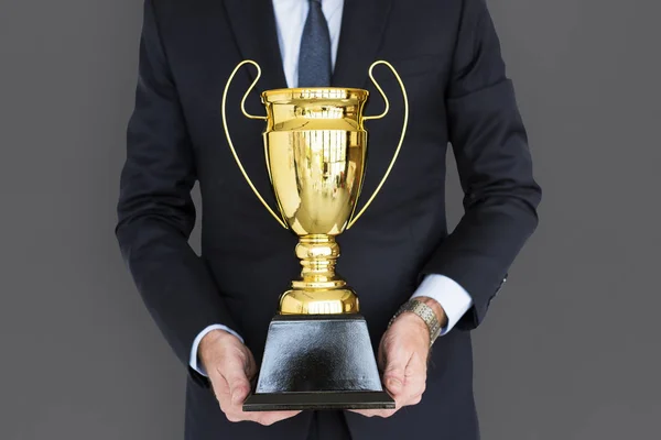 Obchodní muž hospodářství zlatá trofej — Stock fotografie