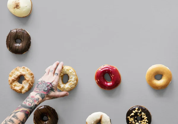 Tatuado mano selección donuts — Foto de Stock