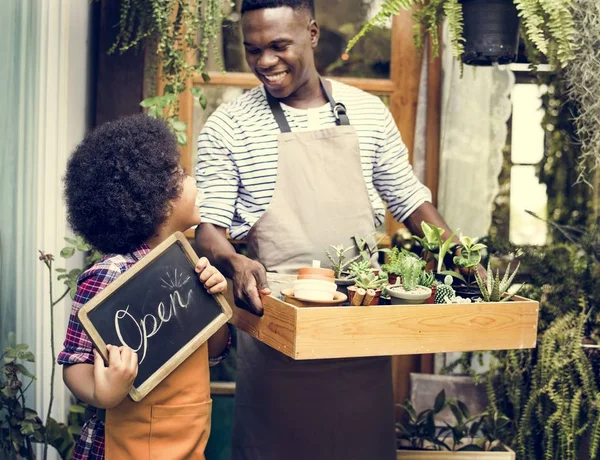 Afrikansk flicka hjälper far i butik — Stockfoto