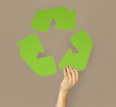 Geri dönüşüm işareti tutan kişi