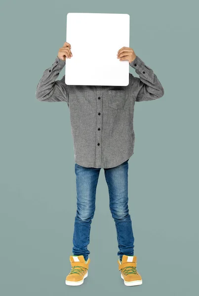 Junge verdeckt Gesicht mit leerem Plakat — Stockfoto