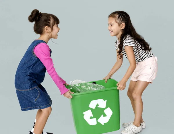 Girls carrying recycling bin — Stock Photo, Image