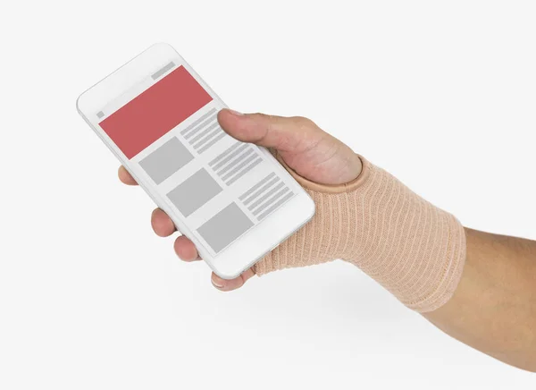Ręka w bandaż trzymając telefon komórkowy — Zdjęcie stockowe