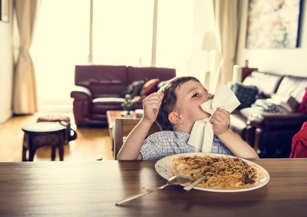 Niño comiendo espaguetis en casa — Foto de Stock