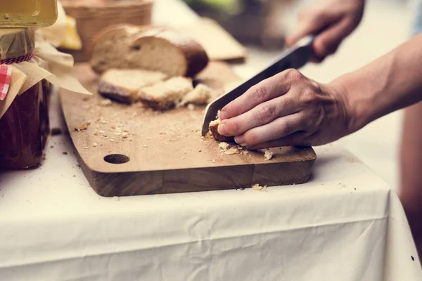 Hands cutting bread — Stock Photo, Image