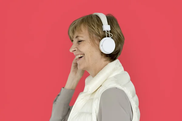 Starsza kobieta słuchania muzyki w słuchawkach — Zdjęcie stockowe
