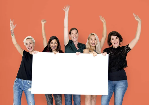 Mujeres sonrientes sosteniendo banner vacío — Foto de Stock