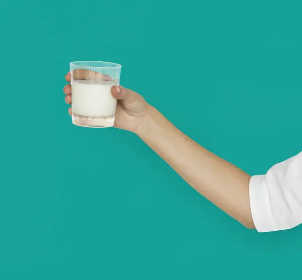 Hand som håller glaset med mjölk — Stockfoto