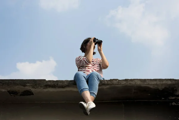 Mujer mirando a través de binocular — Foto de Stock