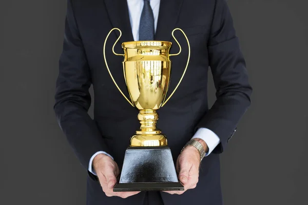 Homem de negócios segurando troféu dourado — Fotografia de Stock