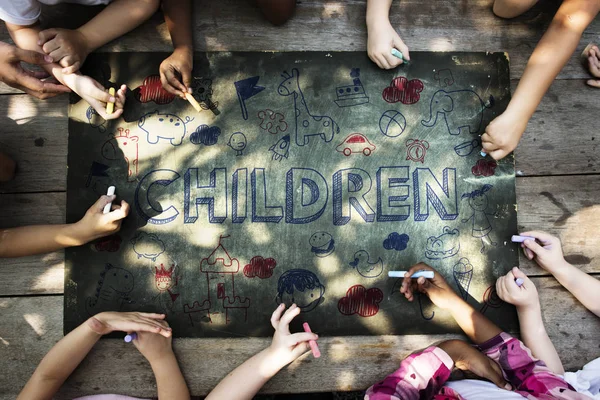 Дети рисуют мелом на черной доске — стоковое фото