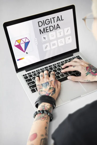 Getatoeëerde persoon typen op laptop. — Stockfoto