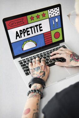 Dövmeli kişi dizüstü bilgisayarda yazarak.