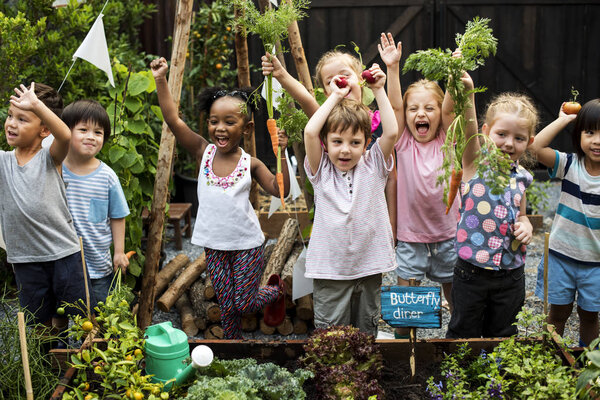 Children in the garden holding hands up