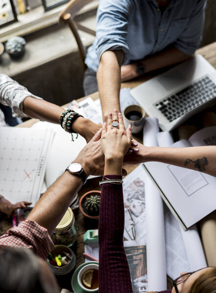 colleagues making stack of hands