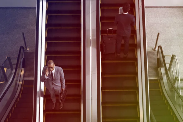 Uomini d'affari che utilizzano scale mobili — Foto Stock