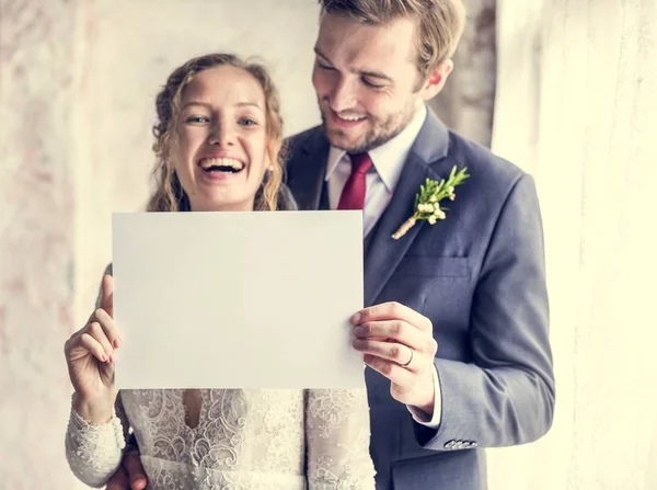 Noiva e noivo mostrando papel em branco — Fotografia de Stock