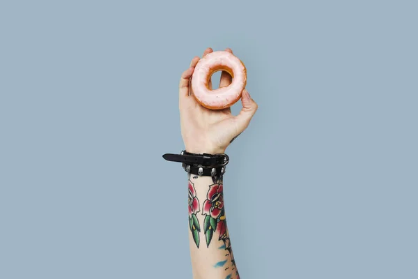 Tatuerade person som innehar donut — Stockfoto