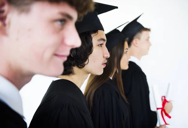 Students wearing graduation caps and gowns — Stock Photo, Image