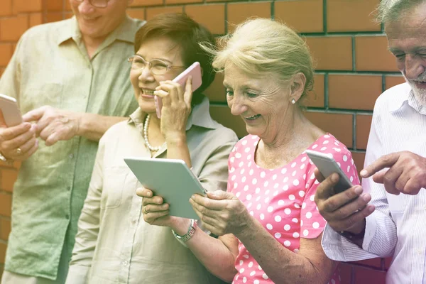 Anziani che utilizzano dispositivi digitali — Foto Stock