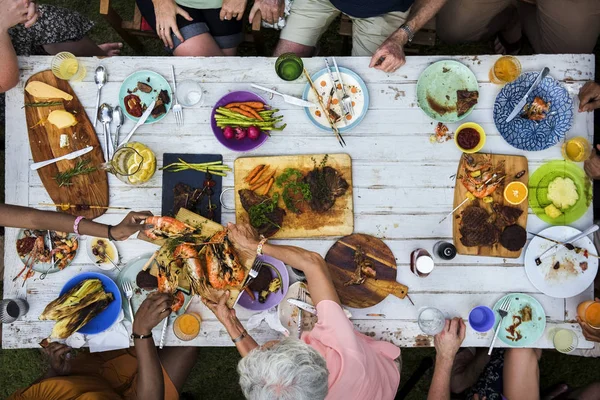Люди сидять за столом з їжею — стокове фото