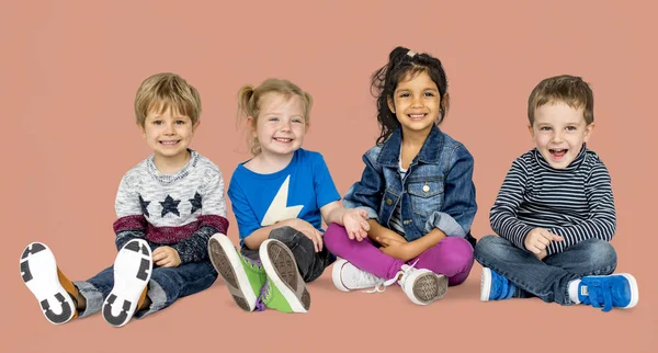 Niños pequeños sentados juntos — Foto de Stock