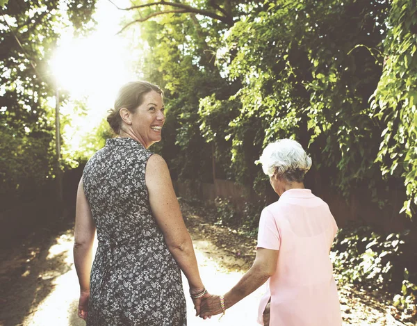 Two women holding hands and walking — Stock Photo, Image