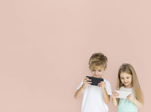 Хлопчик і дівчинка грають на смартфонах — стокове фото