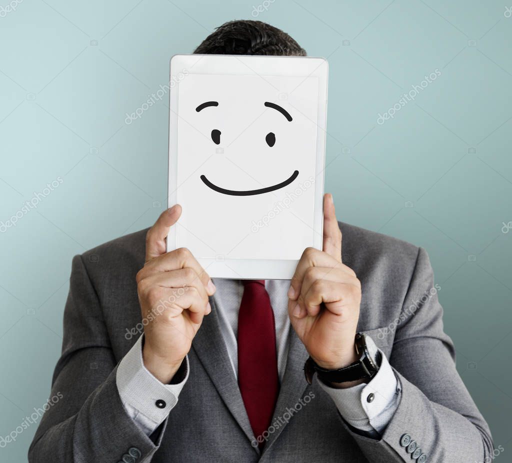 Businessman covering face with digital tablet